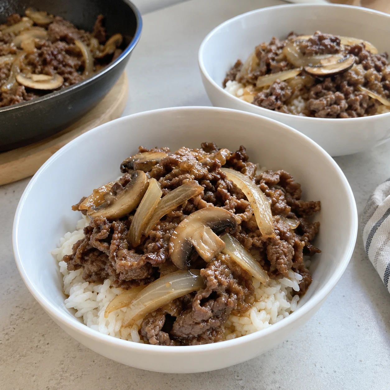 Step 6: Divide the warm rice between two bowls. Add the cooked beef and vegetables, spoon over a little hot pan sauce and top with spring onion if using. Serve immediately using clean utensils.