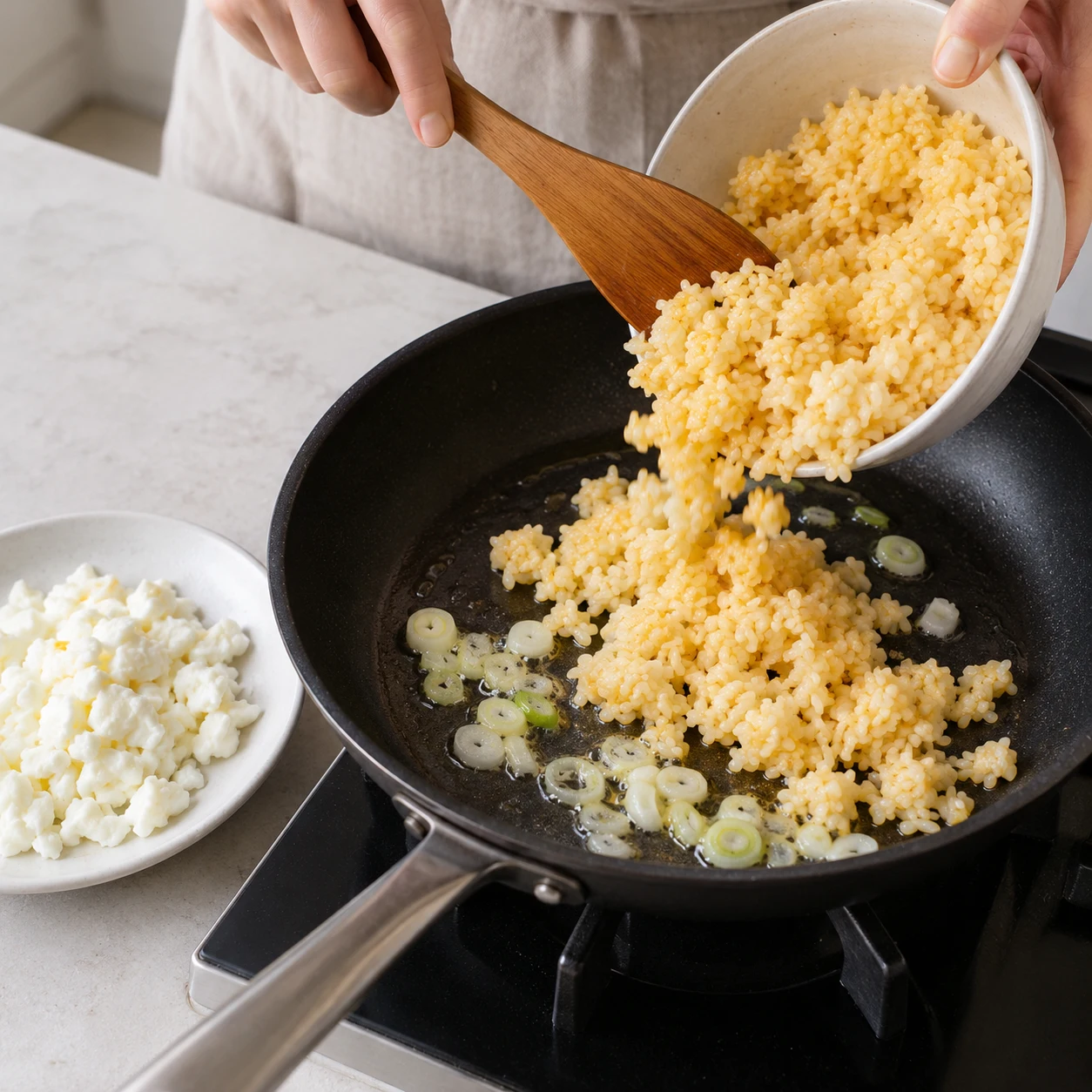 Step 4: Add the remaining 1 level eating spoon of oil to the same pan. Fry the white spring-onion rings over medium heat for 20–30 seconds until fragrant but not brown. Add the yolk-coated rice. If you omit spring onion, skip its frying time and add the rice straight to the oil.