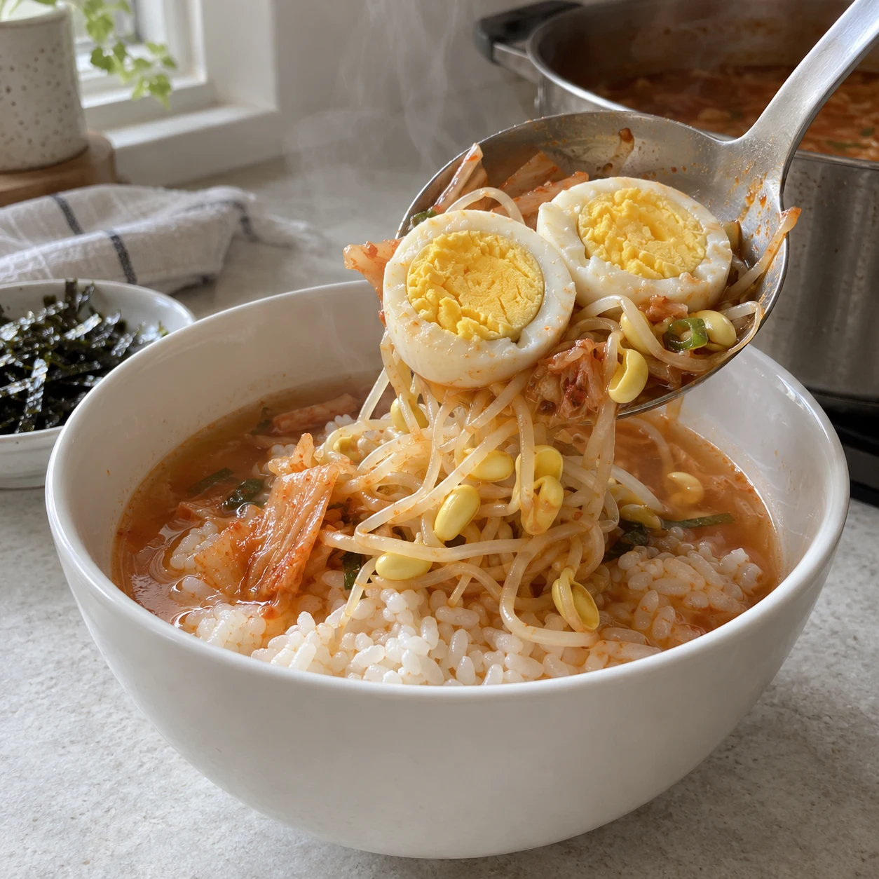 ขั้นตอน 6: ยกไข่ที่สุกเต็มที่หนึ่งฟองลงในแต่ละชาม ใส่ถั่วงอก กิมจิ และน้ำซุปร้อนๆ ลงบนข้าว จากนั้นจึงใส่โนริซอยเล็กน้อย เสิร์ฟทันที โดยแยกน้ำซุปและข้าวส่วนเกินไว้ต่างหากเพื่อเก็บไว้