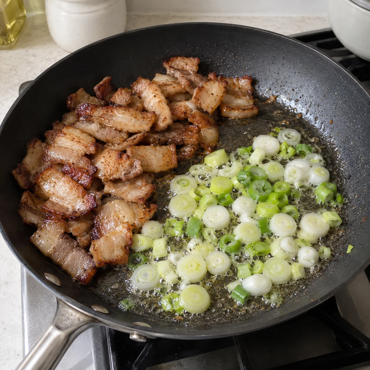 ขั้นตอน 3: ย้ายหมูที่ปรุงสุกไปด้านหนึ่ง ตักไขมันส่วนเกินออกอย่างระมัดระวัง โดยเหลือ ช้อนกินข้าว 1 ช้อน (ปาดเสมอ) ไว้ประมาณในกระทะ เติมน้ำมันเสริม ช้อนชาเล็ก 1 ช้อน เฉพาะเมื่อกระทะแห้งเท่านั้น ใส่ต้นหอมสีขาวลงในไขมันแล้วคนเป็นเวลา 20–30 วินาที