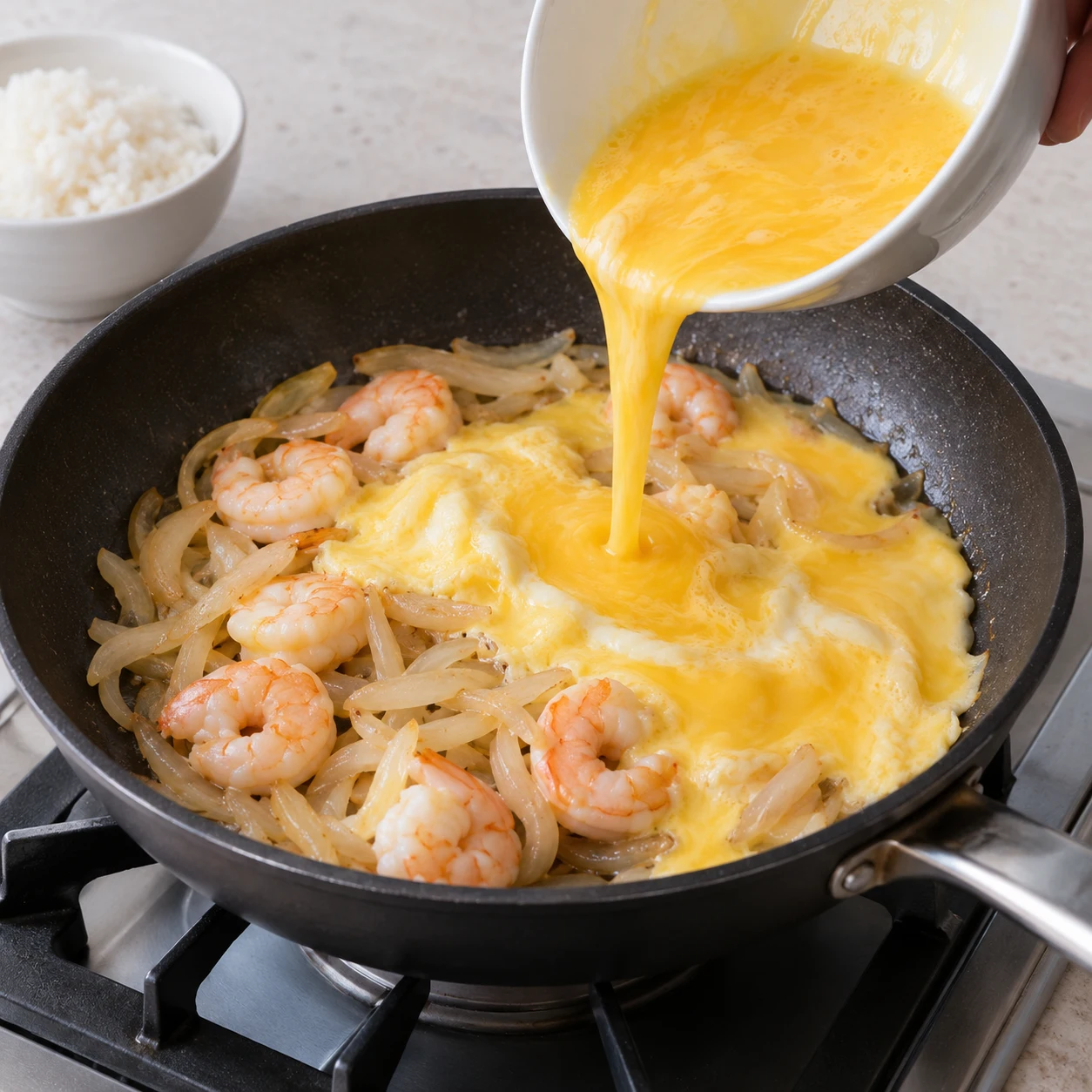ขั้นตอน 5: เทไข่ที่ตีแล้วให้ทั่วกุ้งและหัวหอมที่กำลังเดือดอยู่ ตั้งไฟอ่อน ปิดฝาแล้วปรุงประมาณ 2-3 นาทีจนกว่าไข่ขาวและไข่แดงจะเซ็ตตัวอย่างสมบูรณ์ โดยไม่เหลือไข่เหลว อย่าคนให้เป็นเศษเล็กเศษน้อยแห้ง